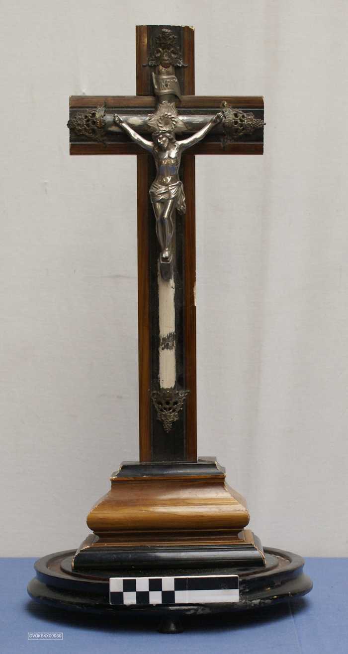 Kruisbeeld op sokkel met stolp